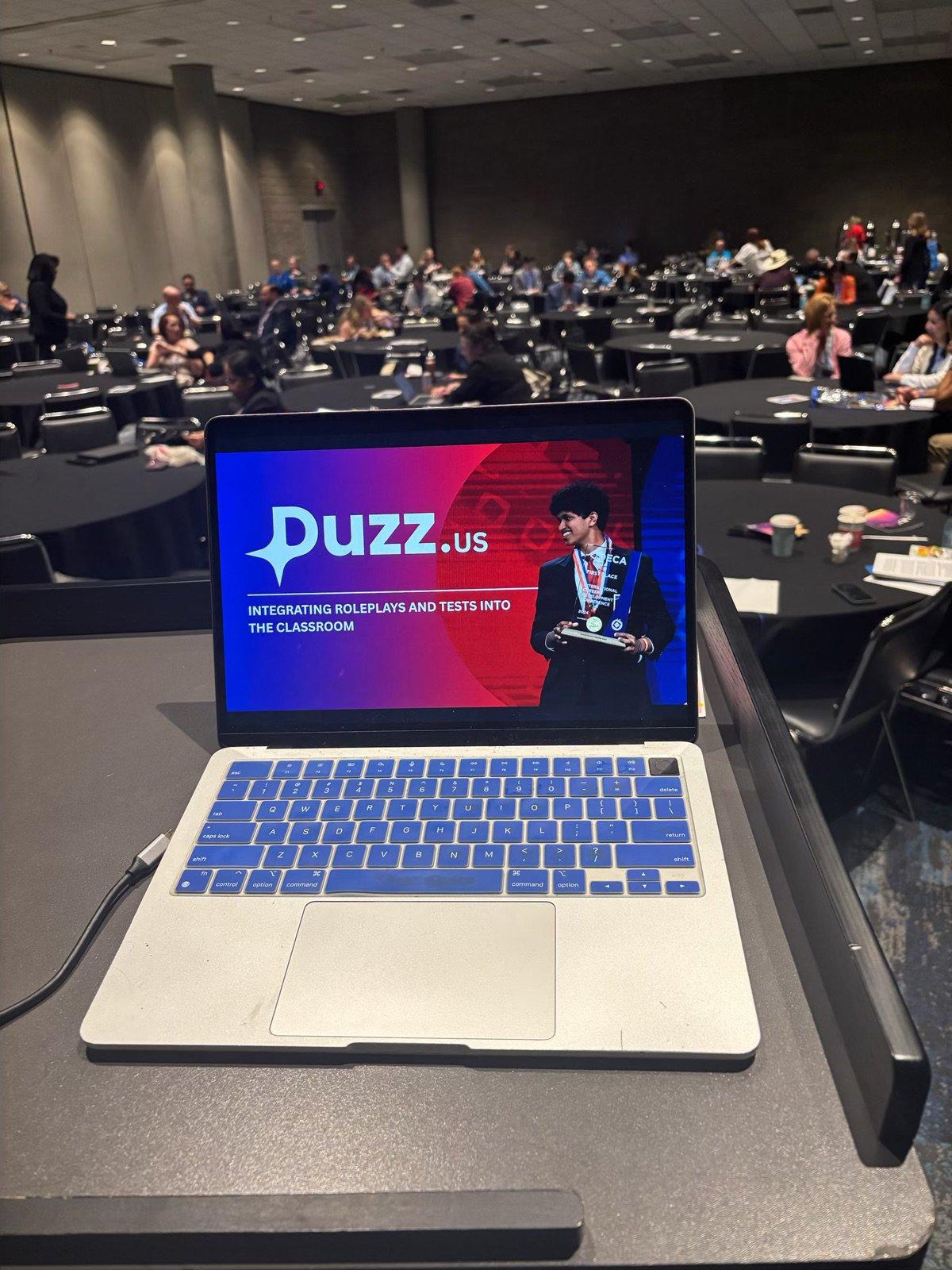 Laptop showing a DUZZ slide in front of a room full of DECA chapter advisors at ICDC